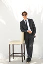 Portrait, fashion and a business man with a chair in studio on a white background for corporate style. Handsome Royalty Free Stock Photo