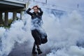 Portrait of fashion model girl in black clothes with the effect of smoke, white fog Royalty Free Stock Photo