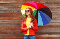 Portrait fashion pretty smiling woman with colorful umbrella in autumn over wooden background wearing red leather jacket Royalty Free Stock Photo