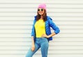 Portrait fashion pretty smiling woman model in colorful clothes posing over white background wearing a pink hat yellow sunglasses Royalty Free Stock Photo