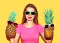 Portrait fashion smiling woman and two pineapple in sunglasses over yellow Royalty Free Stock Photo