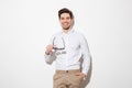 Portrait of fashion young man dressed in shirt smiling and posing on camera holding black sunglasses, over white background with Royalty Free Stock Photo