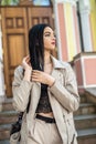 Portrait of fashionable beautiful young woman posing outside against old door of house Royalty Free Stock Photo