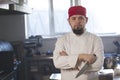 Portrait of a fashionable chef in bandana holding a knife in a kitchen