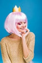 Portrait fashionable joyful young woman with cut pink hair on blue background. Smiling with closed eyes, brightful