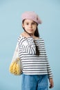 Portrait of a fashionable little girl in french beret holding bag with bananas Royalty Free Stock Photo