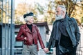 portrait of fashionable senior couple holding hands and looking at each other
