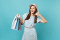 Portrait fashionable smiling beautiful caucasian woman in summer dress, straw hat holding packages bags with purchases Royalty Free Stock Photo