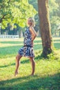 Portrait of fashionable young sensual blonde woman in garden enyoing on the grass field