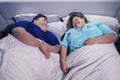 Fat Asian couple chatting before going to bed