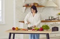 Portrait of fat overweight woman preparing fresh vegetables for salad in the kitchen at home. Royalty Free Stock Photo