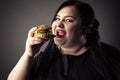 Portrait fat woman eating hamburger closeup