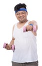 Portrait of fat young man doing exercise with dumbbells make punch