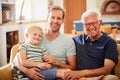 Portrait Of Father With Adult Son And Grandson Relaxing On Sofa And Talking At Home Royalty Free Stock Photo