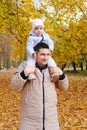 Portrait of a father carrying his cute little daughter on shoulders, baby and daddy with pleasure spending time together Royalty Free Stock Photo