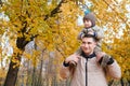 Portrait of a father carrying his cute little son on shoulders, baby and daddy with pleasure spending time together Royalty Free Stock Photo
