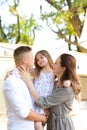 Portrait of father and caucasian mother holding daugher.