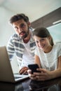 Portrait of father and daughter using laptop and mobile phone in the living room Royalty Free Stock Photo