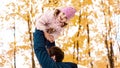 Portrait of a father holds, throws up a happy daughter in his arms, walks in nature on an autumn day Royalty Free Stock Photo
