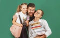 Portrait of father and school kids daughters hugging on blackboard background. Reading book and writing. Dad teaching Royalty Free Stock Photo