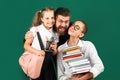 Portrait of father and school kids daughters hugging on blackboard background. Reading book and writing. Dad teaching Royalty Free Stock Photo