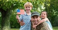 Portrait of father in soldier uniform with their kids at park