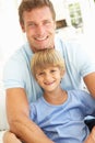 Portrait Of Father And Son Relaxing On Sofa Royalty Free Stock Photo