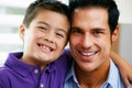 Portrait Of Father And Son Sitting On Sofa At Home Royalty Free Stock Photo