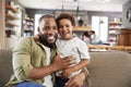 Portrait Of Father And Son Sitting On Sofa In Lounge Together Royalty Free Stock Photo