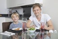 Portrait of father and son smiling at breakfast table Royalty Free Stock Photo