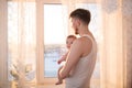 Portrait of father standing near the window with baby Royalty Free Stock Photo