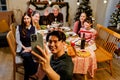 Portrait of father taking selfie with smartphone of family sitting at dinner table celebrating Christmas. Photo of nice excited Royalty Free Stock Photo