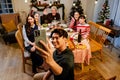 Portrait of father taking selfie with smartphone of family sitting at dinner table celebrating Christmas. Photo of nice excited Royalty Free Stock Photo