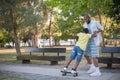 Portrait of father teaching his son to skateboard Royalty Free Stock Photo