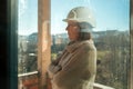 Portrait of female architect on construction site seen through dirty window Royalty Free Stock Photo