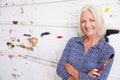 Portrait Of Female Artist Against Paint Covered Wall