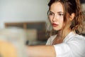 Portrait of a female artist standing next the easel with canvas painting in the studio. Professional female painter draws in Royalty Free Stock Photo