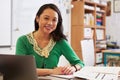 Portrait of female Asian teacher at her desk