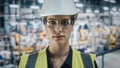 Portrait of Female Automotive Industry Engineer Putting on Safety Glasses at Car Factory Facility