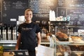 Portrait Of Female Barista Behind Counter In Coffee Shop