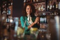 Portrait of female bartender mixing a cocktail drink in cocktail shaker Royalty Free Stock Photo