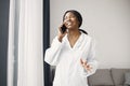 Portrait of female black doctor standing in her office using a phone Royalty Free Stock Photo