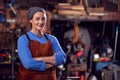 Portrait Of Female Blacksmith Wearing Headscarf Standing In Forge With Folded Arms Royalty Free Stock Photo