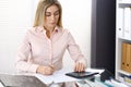 Portrait of female bookkeeper or financial inspector making report, calculating or checking balance. Copy space area