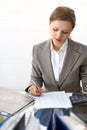 Portrait of female bookkeeper or financial inspector making report, calculating or checking balance. Copy space area