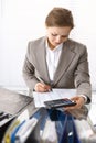 Portrait of female bookkeeper or financial inspector making report, calculating or checking balance. Copy space area