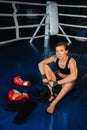 portrait of a female boxer with red gloves after training sitting in the ring Royalty Free Stock Photo