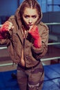 Portrait of female boxer in sport wear with fighting stance against spotlight. fitness blonde girl in sport wear Royalty Free Stock Photo