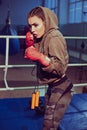 Portrait of female boxer in sport wear with fighting stance against spotlight. fitness blonde girl in sport wear Royalty Free Stock Photo