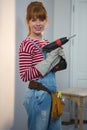 Female carpenter holding drill machine at home Royalty Free Stock Photo